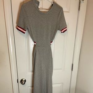 Grey romper with red and black striped outline around collar and end of sleeve